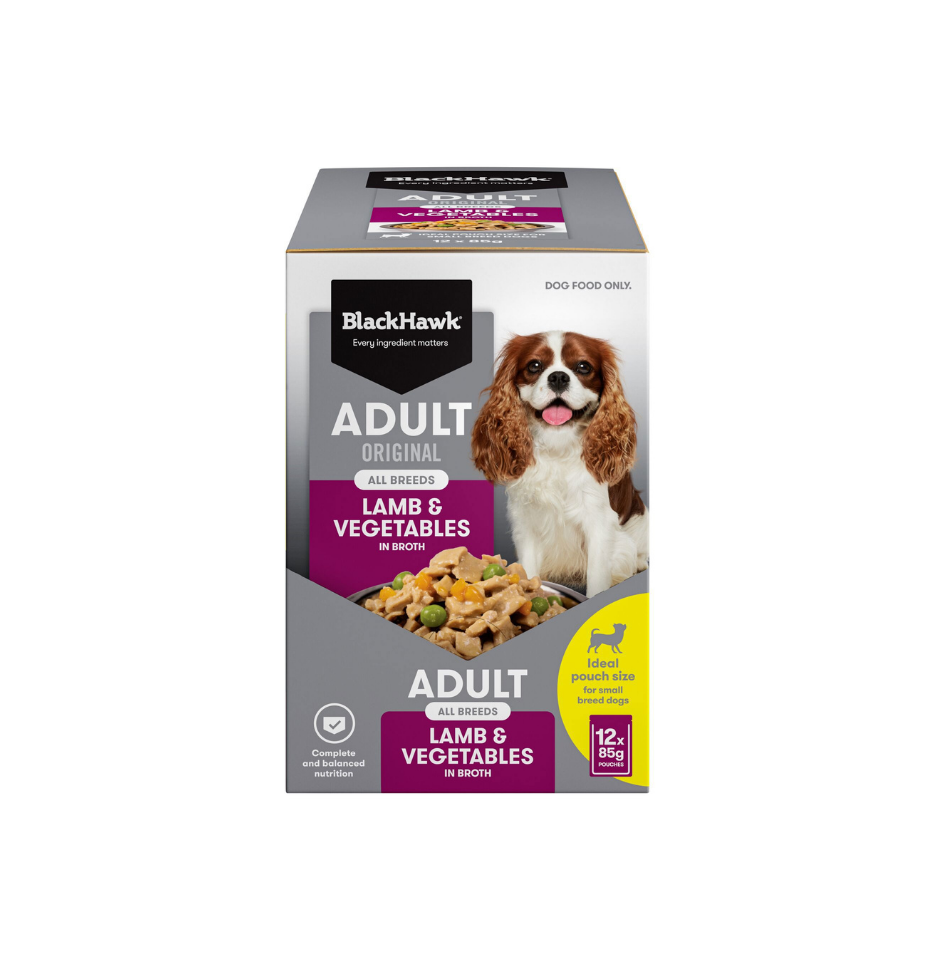 A box of BlackHawk Adult Original Lamb & Vegetables dog food, 12 kg, shown on a plain white background. The packaging features a grey and white design with purple accents, a picture of a brown and white dog, and a yellow circular badge.