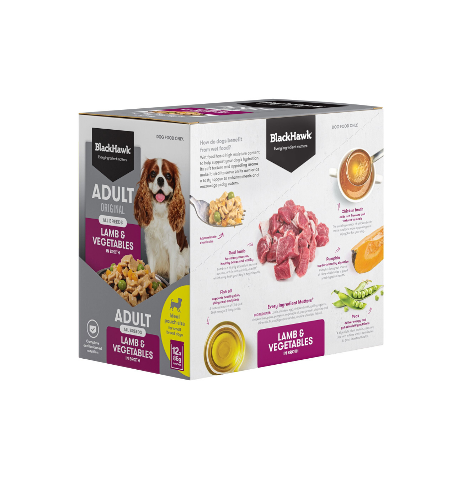 A box of BlackHawk Adult Original Lamb & Vegetables wet food, featuring a white and gray packaging design with purple accents, a picture of a Cavalier King Charles Spaniel, and illustrations of ingredients like chicken, pumpkin, and green beans.