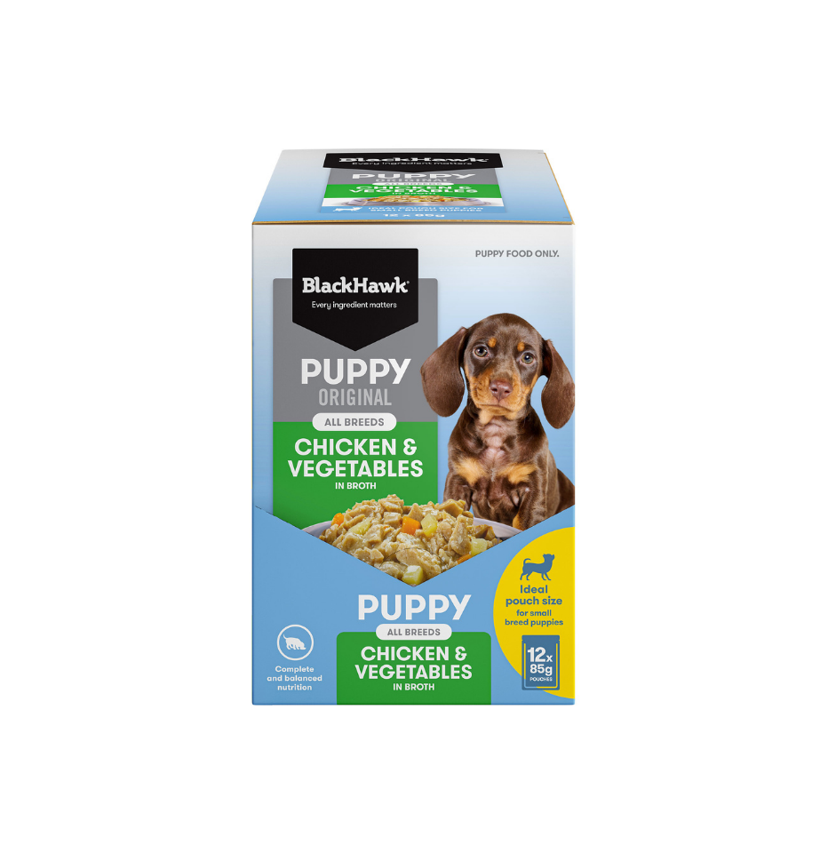 A box of BlackHawk Original Puppy Chicken & Vegetables wet dog food, featuring a dachshund illustration on the front, set against a plain white background.