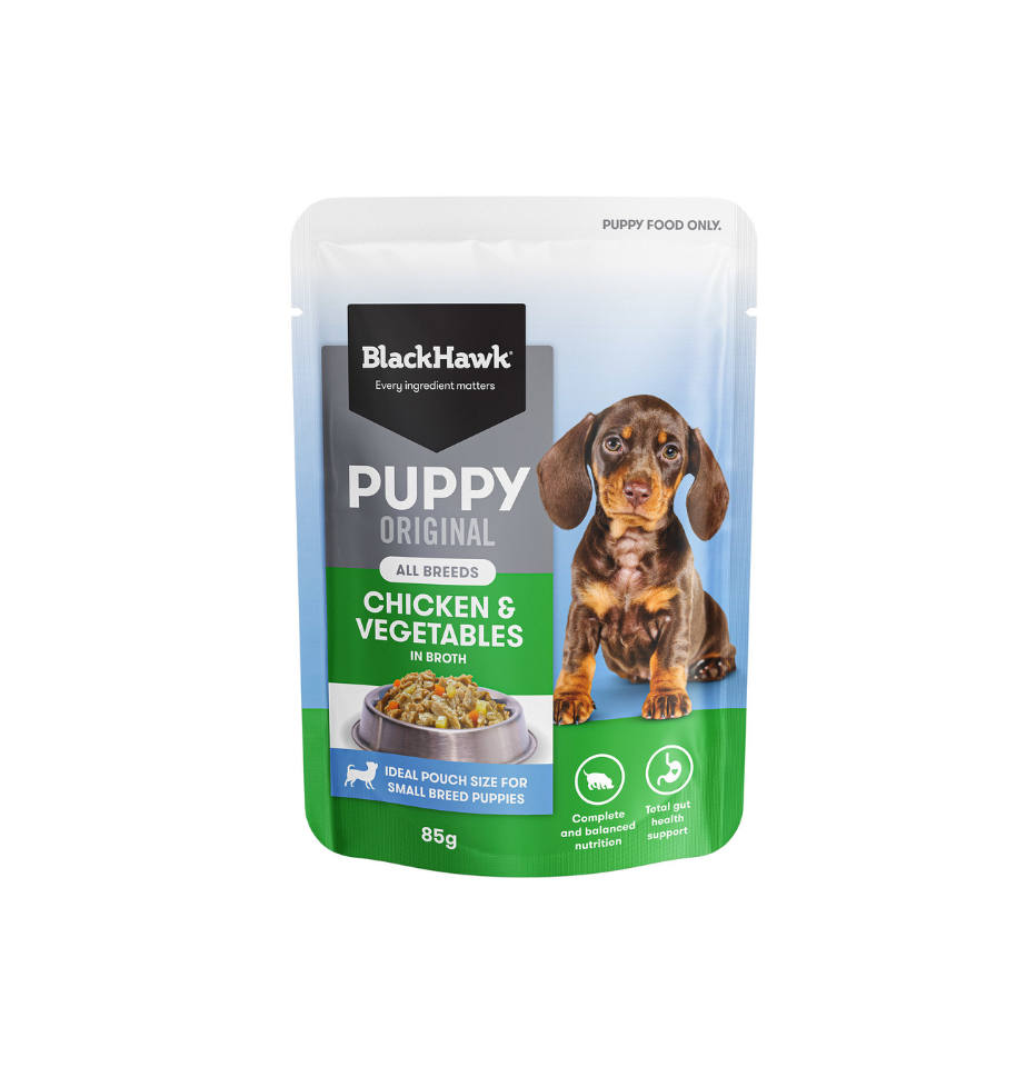 A 85g pouch of BlackHawk Puppy Original Chicken & Vegetables wet dog food, featuring a white and blue background with a dachshund illustration and green accents.