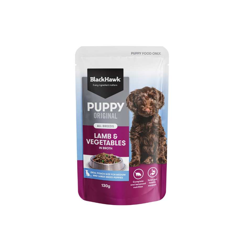 A 130g pouch of BlackHawk Puppy Original Lamb & Vegetables in Broth dog food, featuring a brown puppy graphic on a white, blue, and purple background.