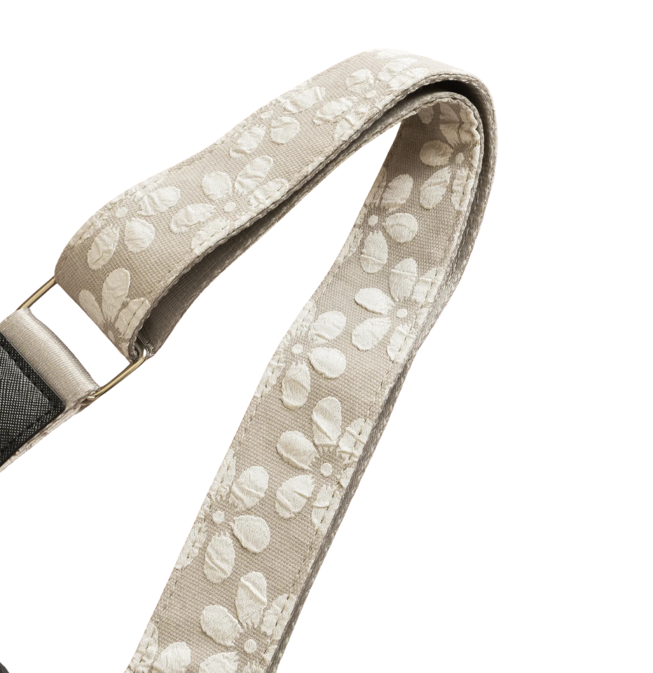 Close-up of a Cocopup London Mocha Flower LUXE Walking Bag Strap with a repeating white floral pattern and a silver metal buckle, shown against a plain white background.