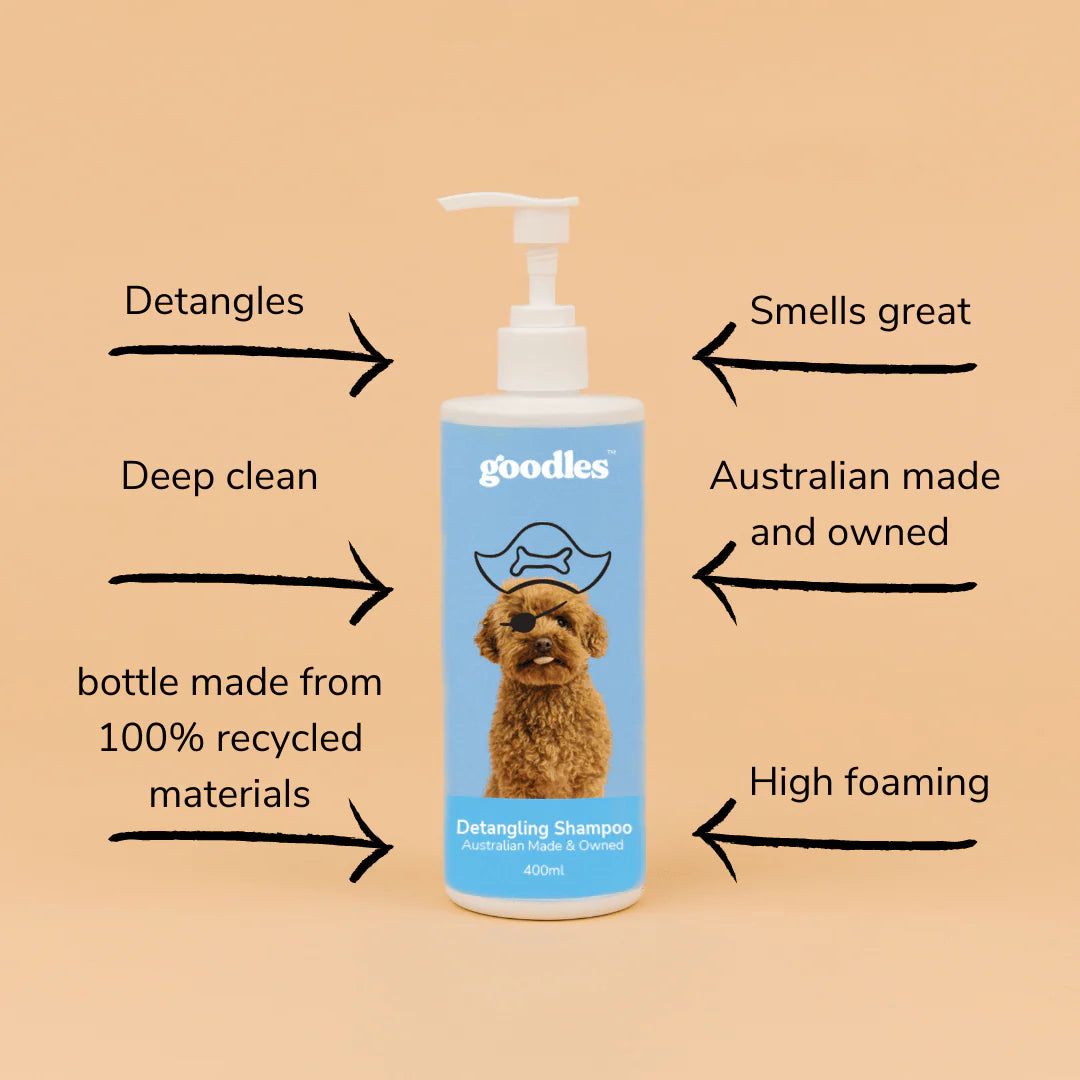 A bottle of Goodles Detangling Dog Shampoo showing its features listed on a beige background