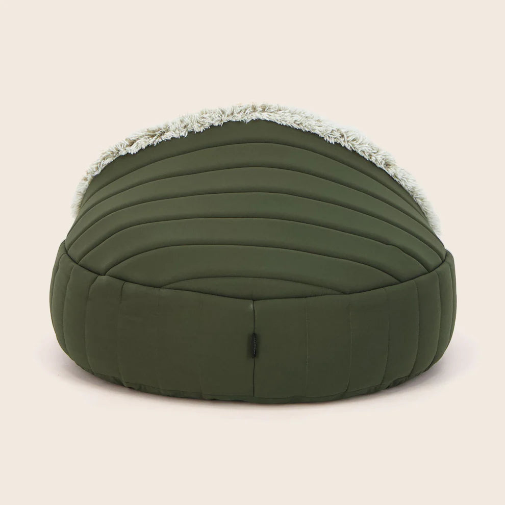 The back of a Snooza Green dog bed with white fur on a beige background