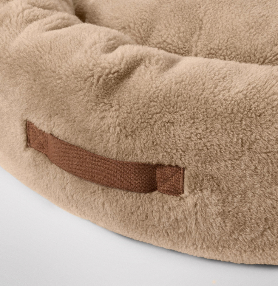 Close-up of MiniJumbuk Sleep Calm Oasis Wool Dog Bed in fawn, showing brown fabric handle detail