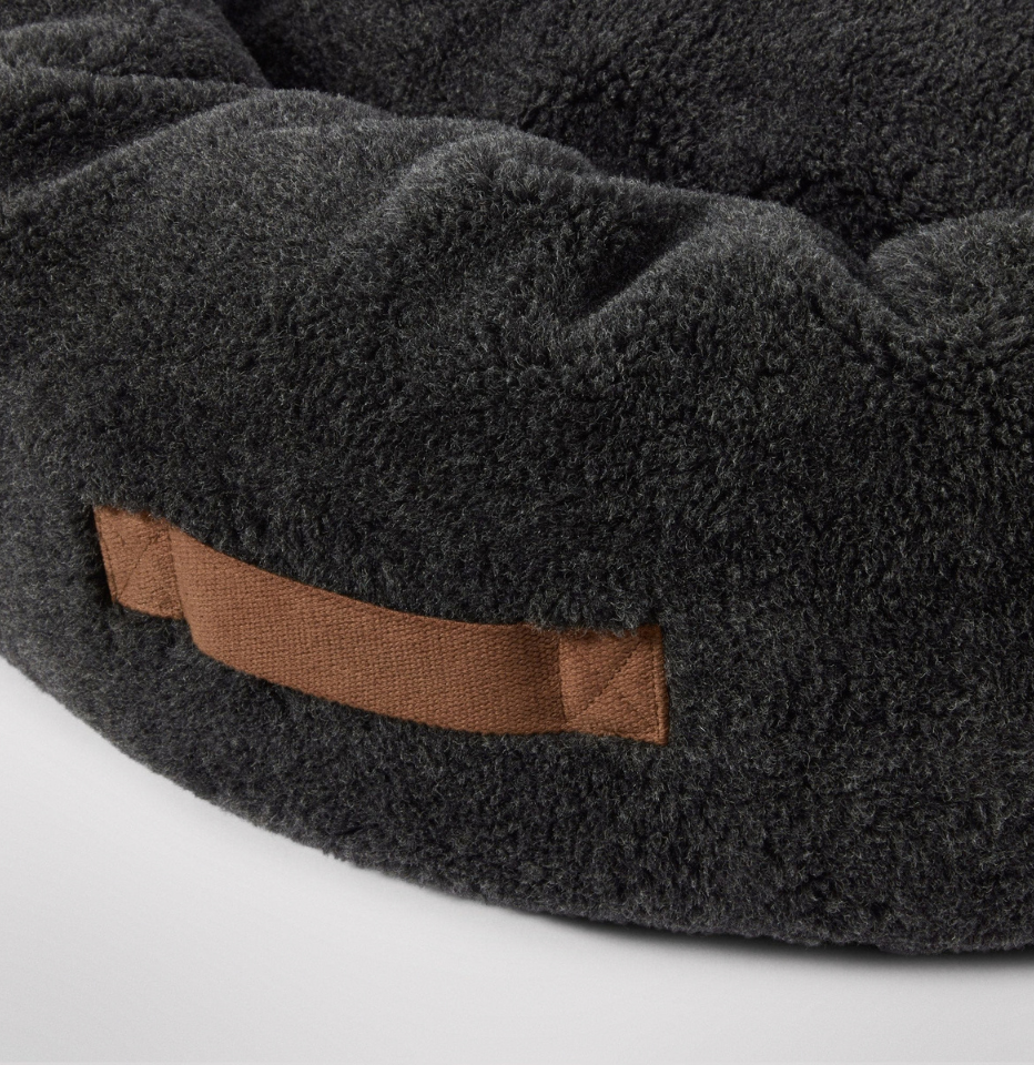 Close-up of MiniJumbuk Sleep Calm Oasis Wool Dog Bed in storm grey, showing brown fabric handle detail
