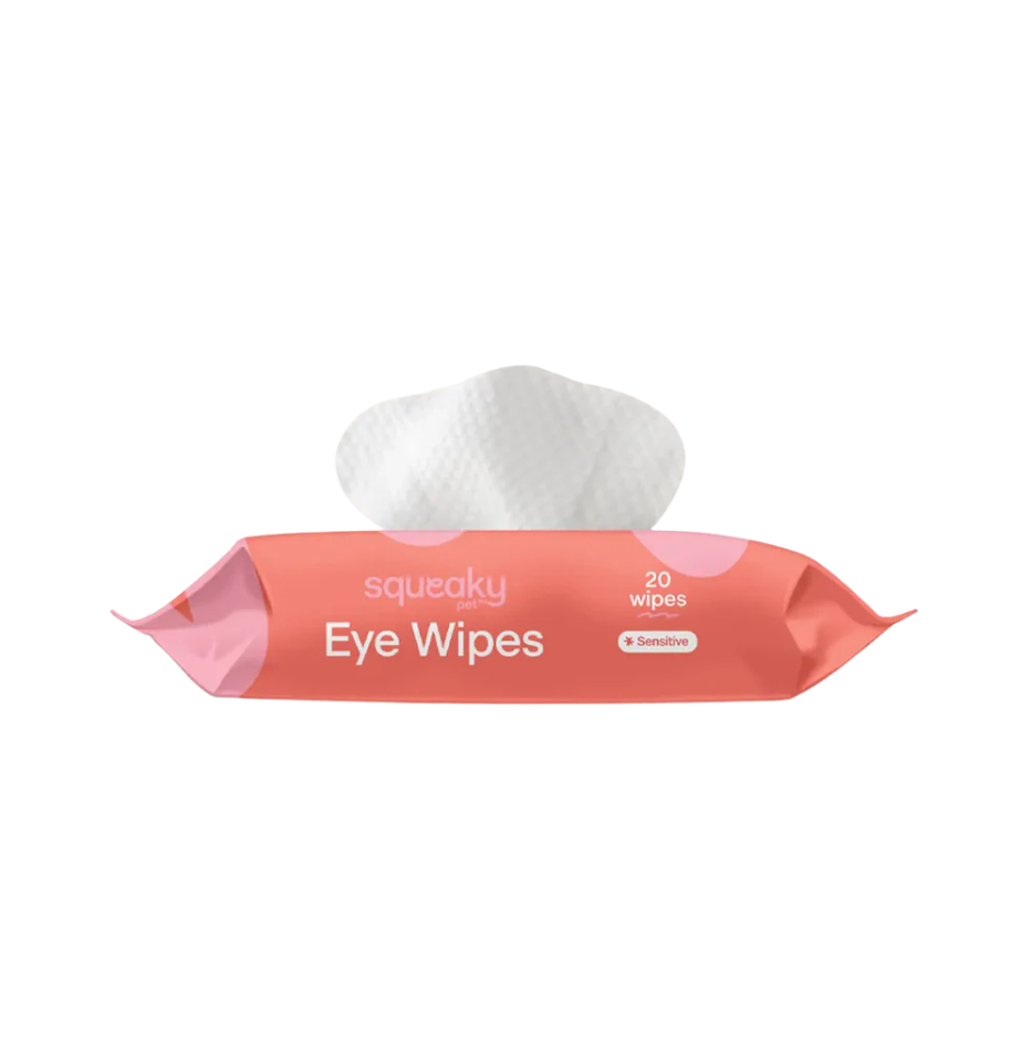 Squeaky brand dog eye wipes for sensitive skin in a pink and coral packaging with a single white wipe pulled out from the top, on a solid white background.